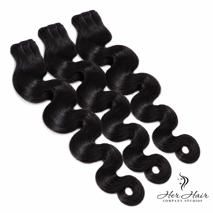 Three bundles of Burmese Raw Body Wave hair from Her Hair Company, showing the soft, natural wave texture and bundle packaging.
