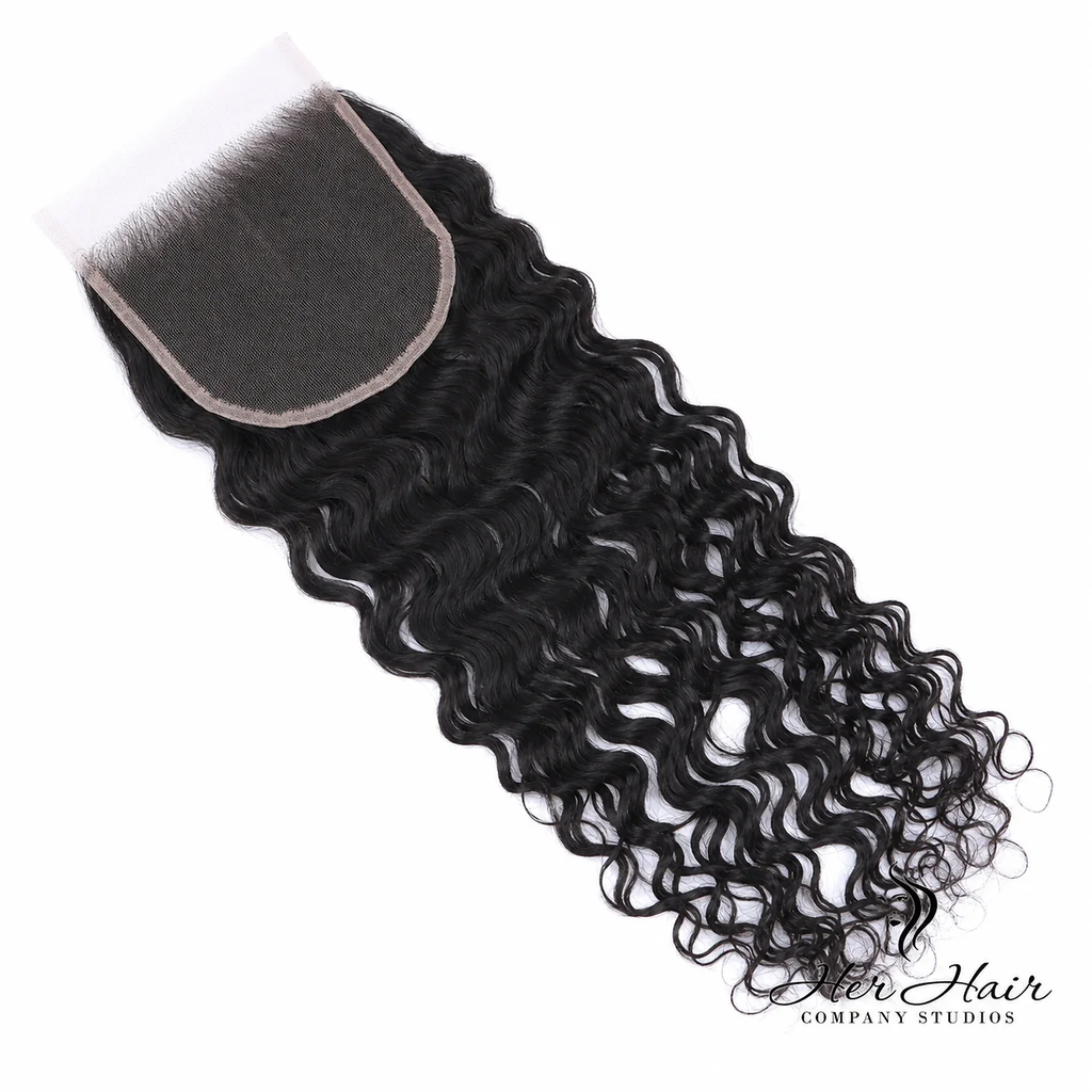 Brazilian raw wavy 5x5 HD lace closure from Her Hair Company, shown from underside with natural hair wave pattern and lace detailing.