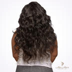 Brazilian wavy hair bundle from Her Hair Company, showing shiny, natural wavy hair with a white top background.