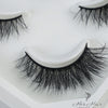 Her Hair Company false eyelashes displayed on a clean surface, showcasing the natural lash style and length for enhanced eye beauty.