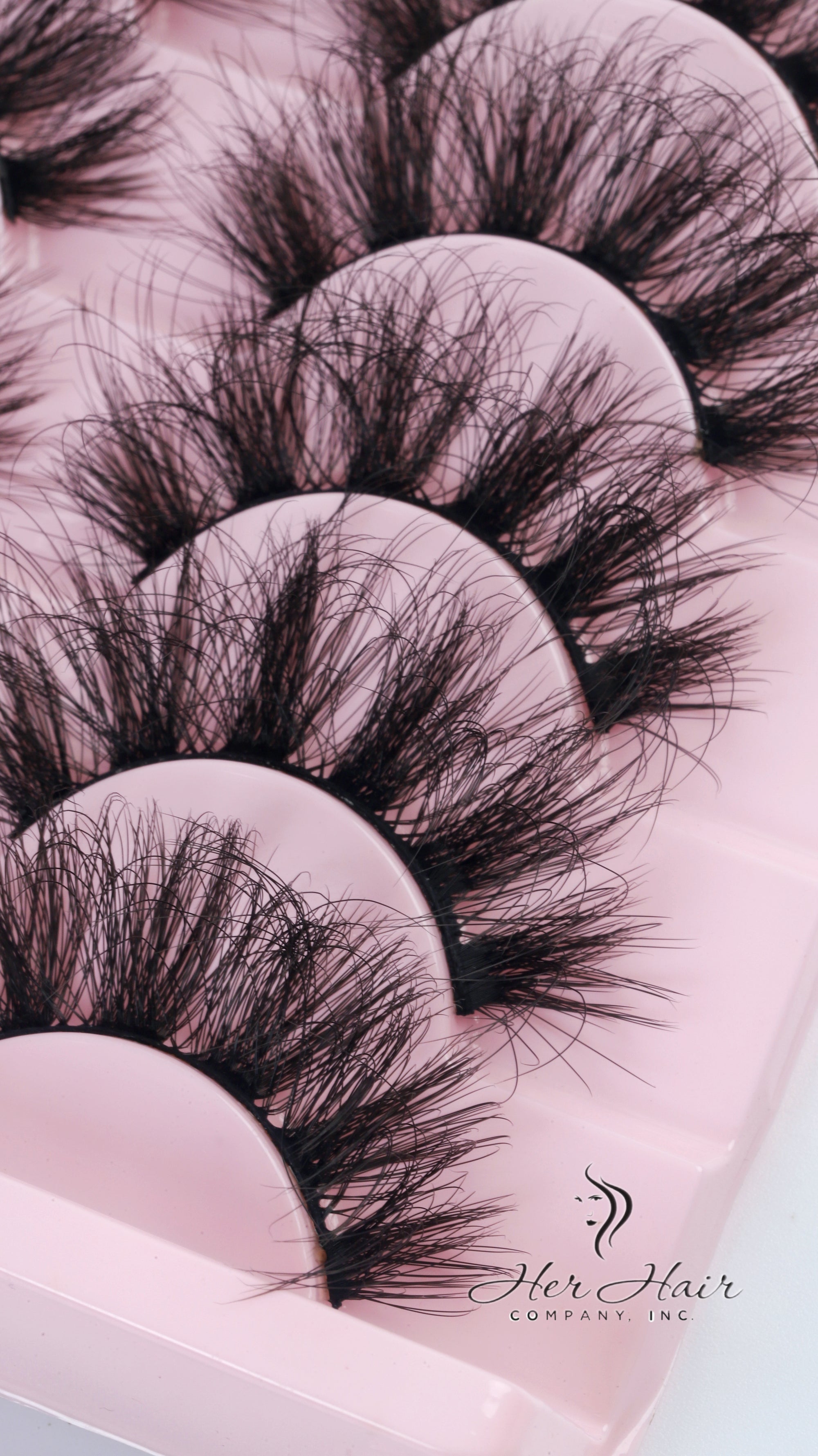 Her Hair Company false eyelashes showcasing long, voluminous black lash extensions with a natural curl.