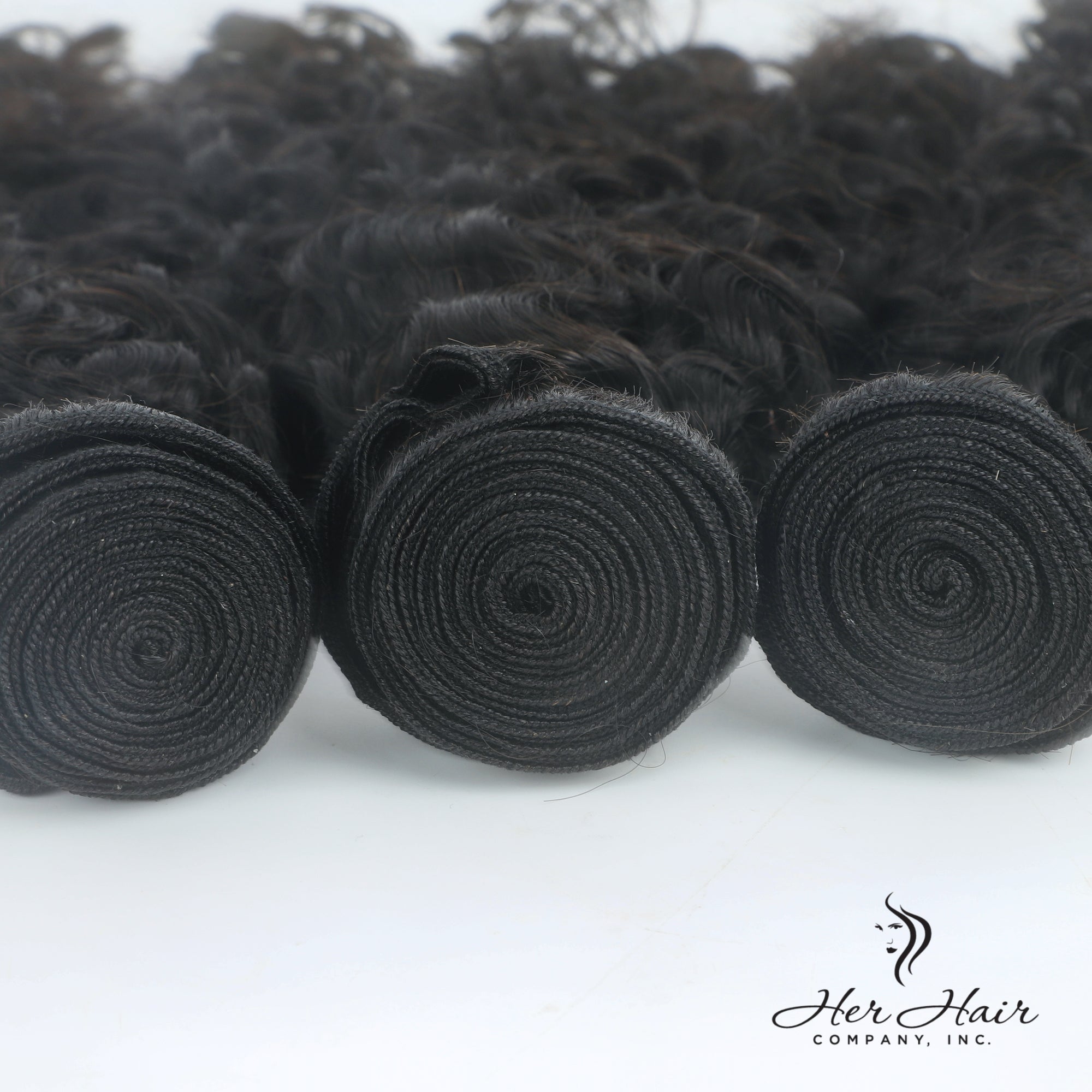 Three bundles of Brazilian Water Wave hair from Her Hair Company, showcasing shiny, wavy natural hair extensions.