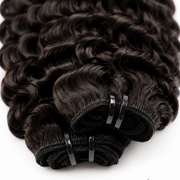 Three bundles of Burmese raw curly hair from Her Hair Company, showing full, natural curly hair texture in standard bundle size.