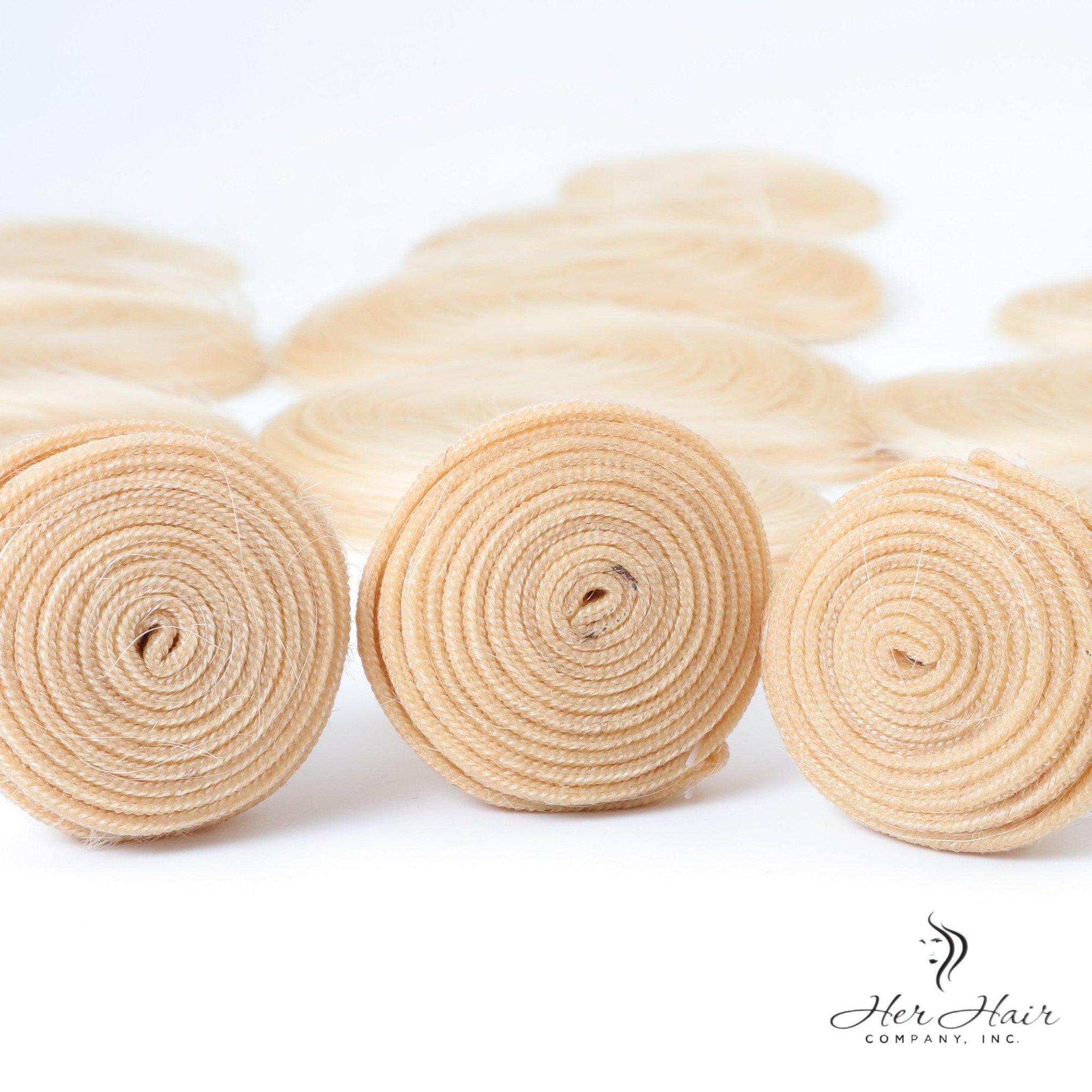 Four bundles of Brazilian 613# hair in a standard bundle pack, showcasing light blonde, silky, and straight hair strands.